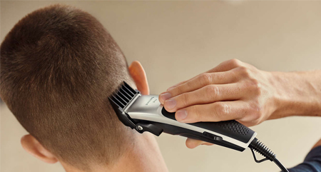 Hombre cortándose el pelo con cortapelos